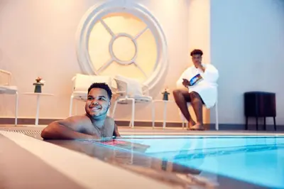 a man laying in a swimming pool with a therapist at Van der Valk Hotel Park Lane Antwerpen in Antwerp