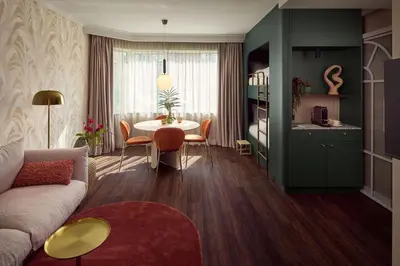 a living room with a couch and a table with chairs at Van der Valk Hotel Park Lane Antwerpen in Antwerp