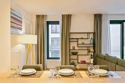 a dining room with a table and a couch at Two Bedroom Apartment with Amazing View in Center in Brussels