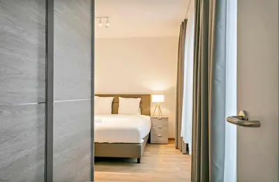 a bedroom with a bed and a door with a mirror at Two Bedroom Apartment with Amazing View in Center in Brussels