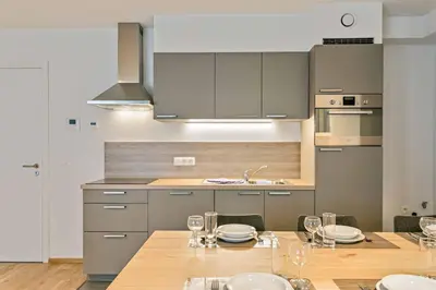 a kitchen with a table with plates and wine glasses at Two Bedroom Apartment with Amazing View in Center in Brussels
