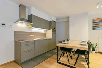 a kitchen with a table with chairs and a sink at Two Bedroom Apartment with Amazing View in Center in Brussels