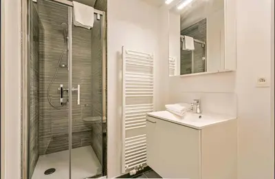 a white bathroom with a shower and a sink at Two Bedroom Apartment with Amazing View in Center in Brussels