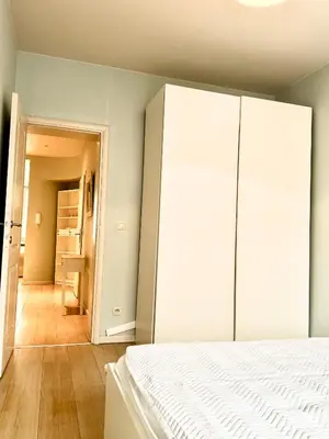 a bedroom with a white bed and a closet at Beautiful 2 bedroom familiar luxury apartment in Brussels