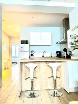 a kitchen with a counter with two stools at Beautiful 2 bedroom familiar luxury apartment in Brussels