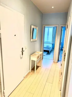a hallway with a door and a table in a room at Beautiful 2 bedroom familiar luxury apartment in Brussels