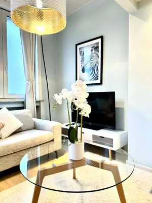 a living room with a couch and a glass table at Beautiful 2 bedroom familiar luxury apartment in Brussels
