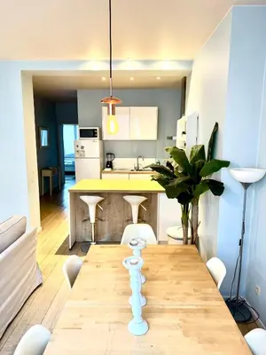a kitchen with a wooden table and a dining room at Beautiful 2 bedroom familiar luxury apartment in Brussels