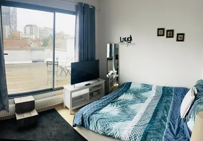 a bedroom with a bed and a flat screen tv at Surplombant louisa in Brussels
