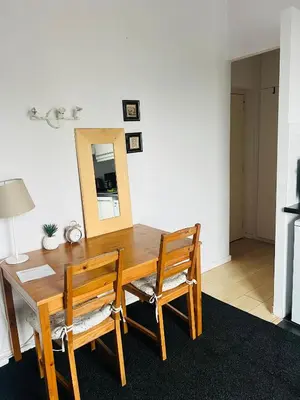 a dining room table with two chairs and a mirror at Surplombant louisa in Brussels