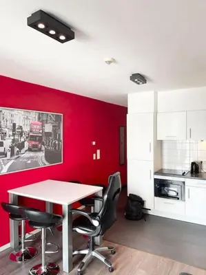 a kitchen with red walls and a table and chairs at Appartement in Brussels Centre in Brussels