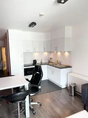 a kitchen with white cabinets and a table and chairs at Appartement in Brussels Centre in Brussels