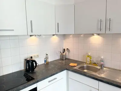 a kitchen with white cabinets and a sink at Appartement in Brussels Centre in Brussels