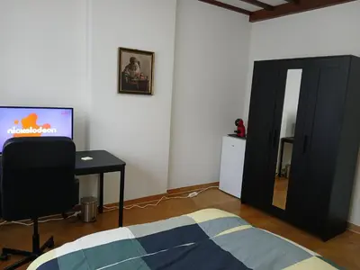 a bedroom with a bed and a desk and a mirror at Assenaar in Asse