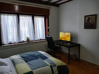 a bedroom with a bed and a desk with a computer at Assenaar in Asse