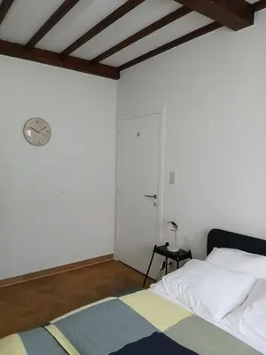 a bedroom with a bed and a clock on the wall at Assenaar in Asse
