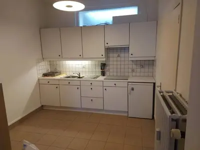 a kitchen with white cabinets and a sink and a window at Charming Apartment in Haren, Brussels - 40 sqm of Comfort in Brussels