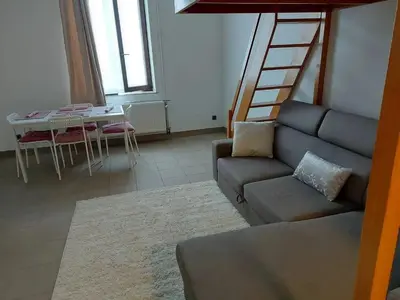 a living room with a couch and a ladder at Charming Apartment in Haren, Brussels - 40 sqm of Comfort in Brussels