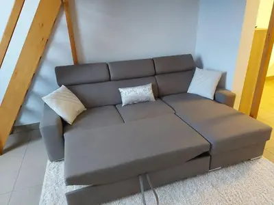 a brown couch with pillows in a living room at Charming Apartment in Haren, Brussels - 40 sqm of Comfort in Brussels