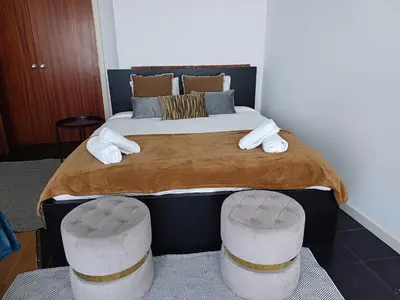 a bedroom with a large bed with two stools at Prime Nest Cozy Studio EU Quarter in Brussels
