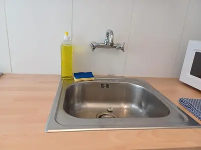 a kitchen sink with a soap bottle on top of it at Prime Nest Cozy Studio EU Quarter in Brussels