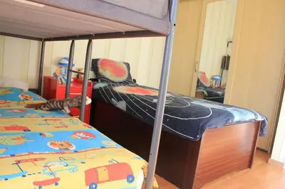 a bedroom with two beds and a bunk bed with a car bed at Maison Spacieuse near Brussels in Meise
