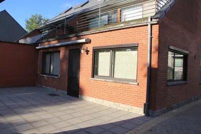 a red brick building with a black door on it at Maison Spacieuse near Brussels in Meise