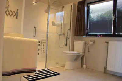 a bathroom with a toilet and a glass shower at Maison Spacieuse near Brussels in Meise