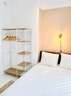 a bedroom with a white bed and a book shelf at Chez Louise - A haven of peace in Brussels in Brussels