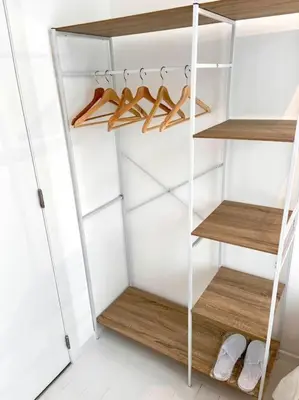 a white closet with wooden shelves and hangers at Chez Louise - A haven of peace in Brussels in Brussels