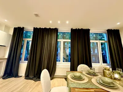 a dining room with black curtains and a table and chairs at Luxury Suites Park by Rikas Hotels in Antwerp