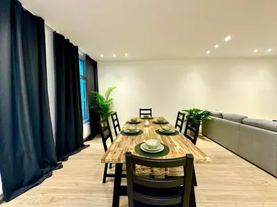 a dining room with a long wooden table and chairs at Luxury Suites Park by Rikas Hotels in Antwerp