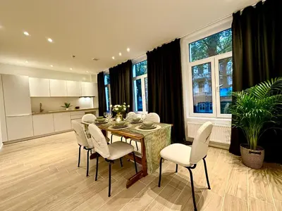 a kitchen and dining room with a table and chairs at Luxury Suites Park by Rikas Hotels in Antwerp