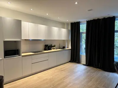 a kitchen with white cabinets and black curtains at Luxury Suites Park by Rikas Hotels in Antwerp