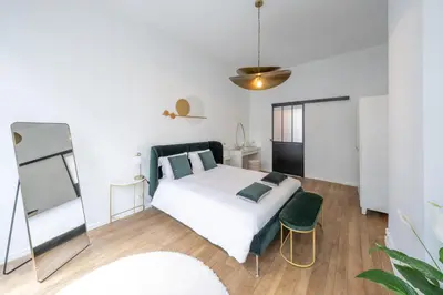 a bedroom with a white bed and a mirror at Your serenity bubble - Brussels center in Brussels