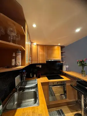 a kitchen with wooden cabinets and a sink at Lisa appartement Brussels in Brussels
