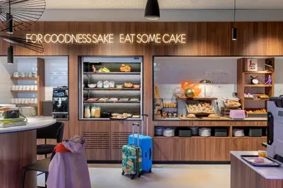 a bakery with a suitcase in front of a store at Moxy Antwerp in Antwerp