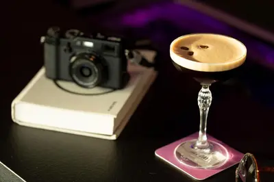 a camera and a martini glass on a table at Moxy Antwerp in Antwerp