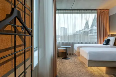 a hotel room with two beds and a window at Moxy Antwerp in Antwerp