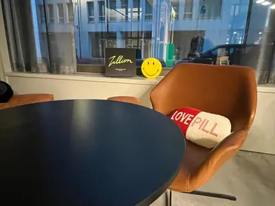a black table and a chair with a pillow on it at Moxy Antwerp in Antwerp