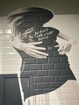 a mural of a man leaning against a brick wall at Moxy Antwerp in Antwerp
