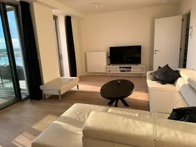 a living room with a couch and a flat screen tv at Luxurious Apartment with Panoramic View in Antwerp
