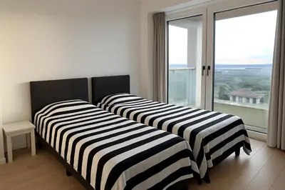 two beds in a room with a large window at Luxurious Apartment with Panoramic View in Antwerp