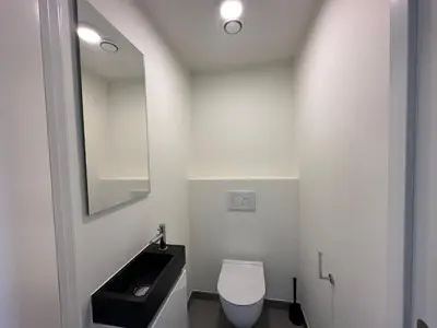 a bathroom with a white toilet and a sink at Luxurious Apartment with Panoramic View in Antwerp