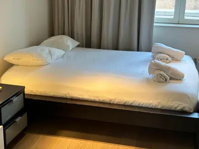 a bed with towels on top of it with a window at Luxurious Two Bedroom Apartment in Brussels