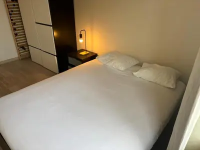 a bedroom with a large white bed and a lamp at Luxurious Two Bedroom Apartment in Brussels
