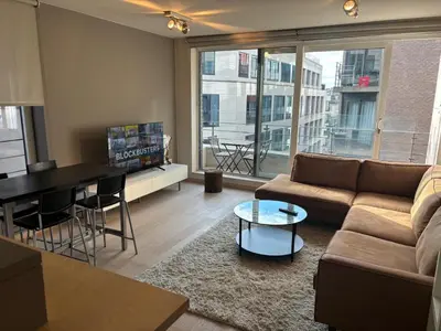 a living room with a couch and a table at Luxurious Two Bedroom Apartment in Brussels