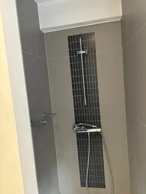 a bathroom with a shower with a glass door at Luxurious Two Bedroom Apartment in Brussels