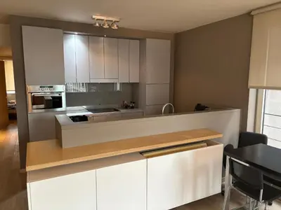 a kitchen with white cabinets and a counter top at Luxurious Two Bedroom Apartment in Brussels