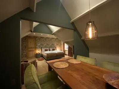 a dining room with a table and a bed at B&B de Graaf van Poppel in Poppel